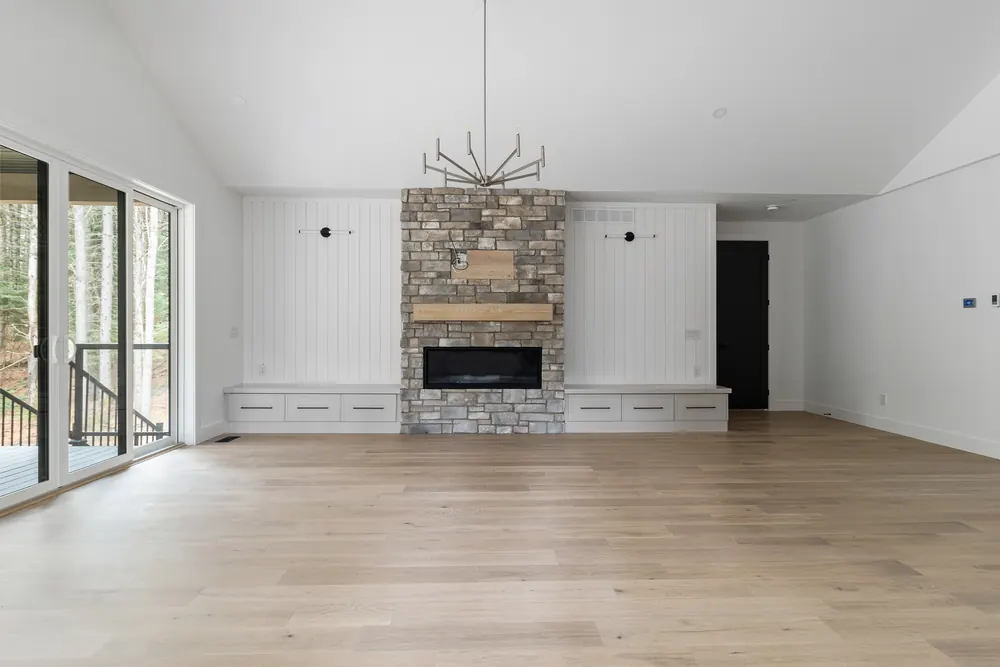 Great room at Dwight Beach Road with a stone fireplace under a vaulted ceiling