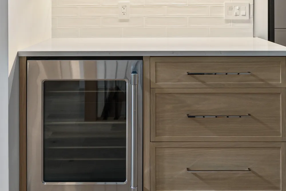Servery at Dwight Beach Road with oak cabinetry and a beverage fridge